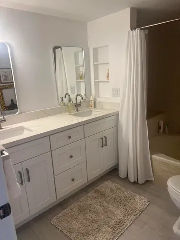 a bathroom with a double vanity sink and a mirror