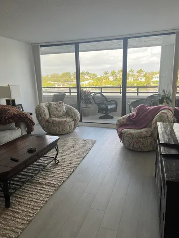 a living room with furniture and a floor to ceiling window