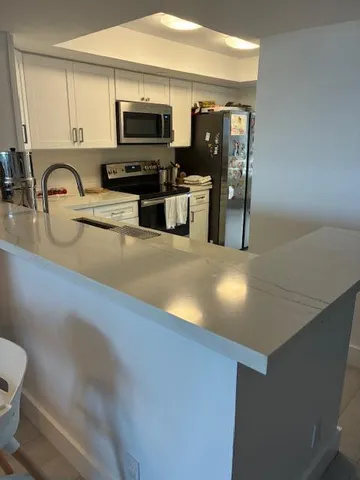 a kitchen with stainless steel appliances a stove a sink and a microwave