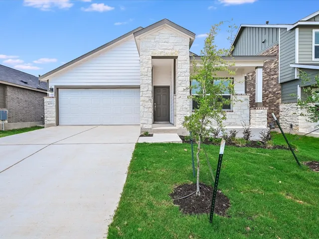 a front view of a house with a garden and plants
