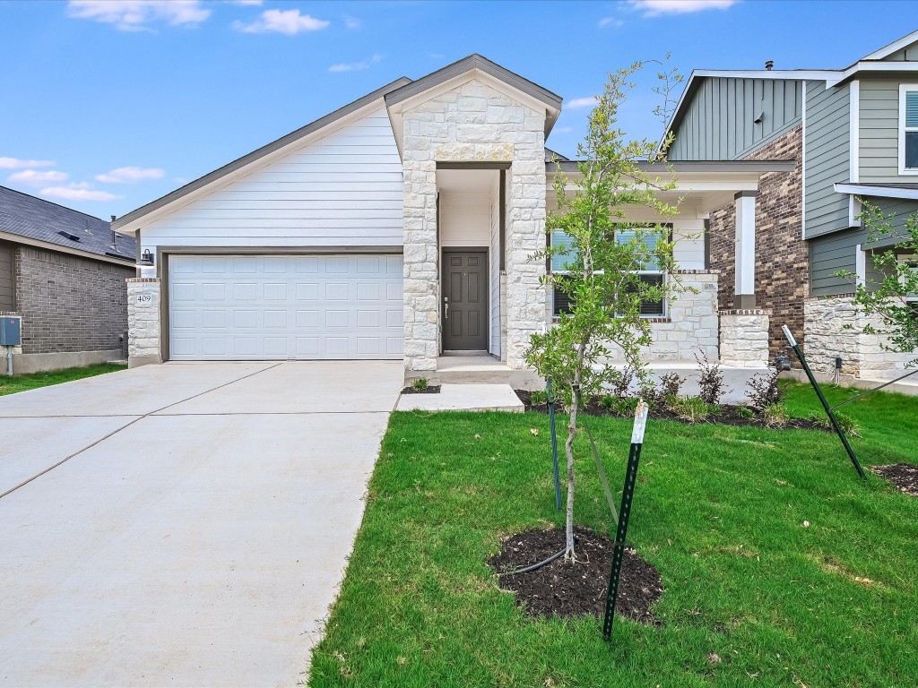 a front view of a house with a garden and plants