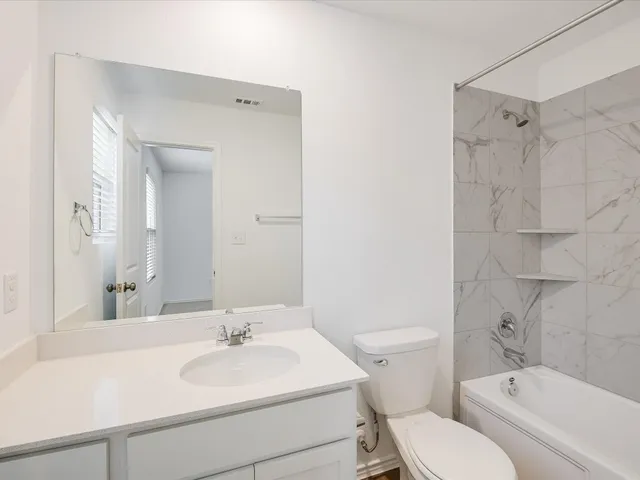 a bathroom with a sink toilet vanity and shower