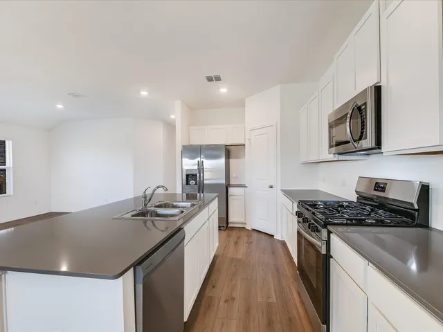 a kitchen with stainless steel appliances granite countertop a sink stove and microwave