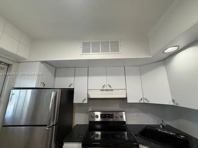 a kitchen with a refrigerator and a stove
