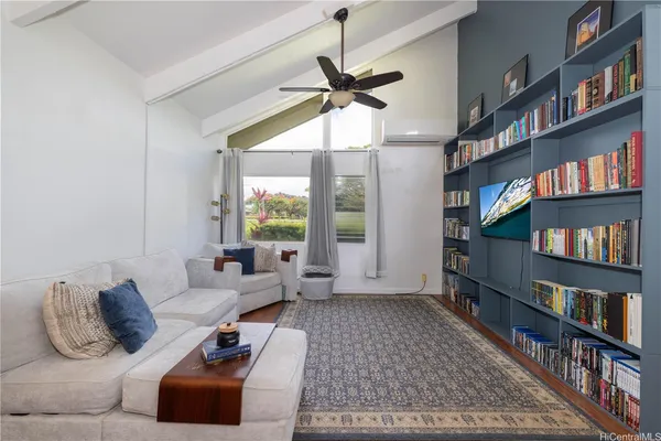 a living room with furniture hard wood floor and a book shelf