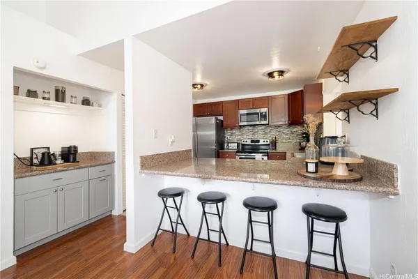 a kitchen with stainless steel appliances granite countertop a sink a stove and chairs