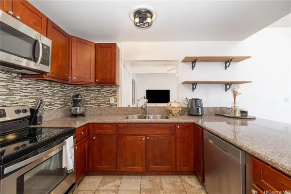 a kitchen with stainless steel appliances granite countertop a sink stove and cabinets
