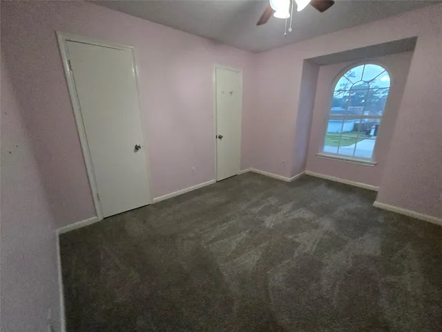 an empty room with windows and fireplace