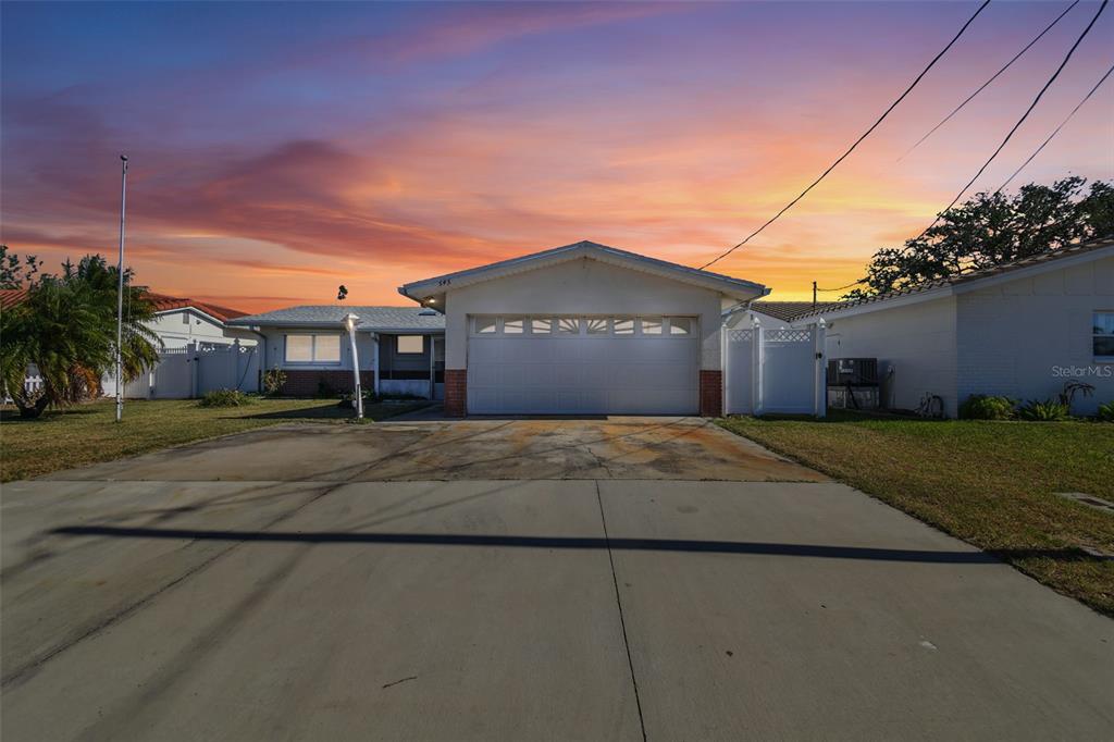 545 Lillian Drive Madeira Beach, FL 33708 - Photo 2 of 100 a front view of a house with a yard and garage