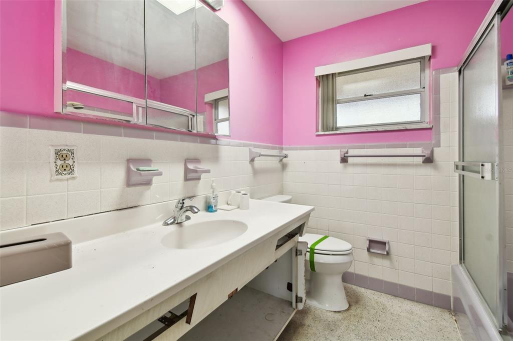 545 Lillian Drive Madeira Beach, FL 33708 - Photo 38 of 100 a bathroom with a sink a toilet and mirror