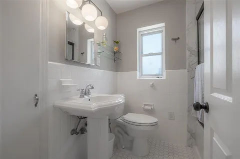 a bathroom with a sink toilet and a mirror