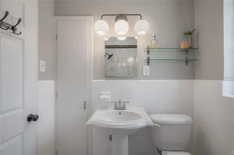 a bathroom with a sink a toilet and mirror