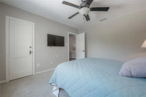 a bedroom with a bed and a flat tv screen on the dresser