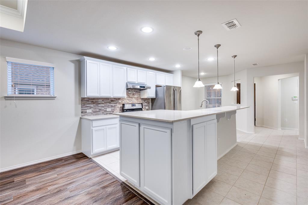 7793 Gulf Walk Road Frisco, TX 75036 - Photo 14 of 28 a kitchen with kitchen island a sink stainless steel appliances and white cabinets