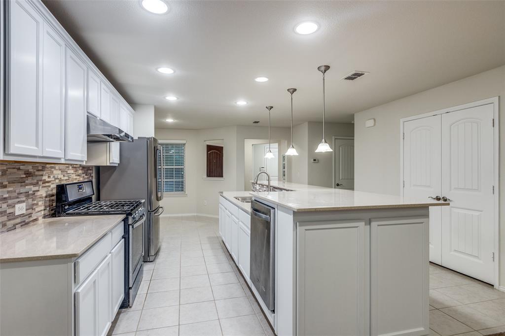 7793 Gulf Walk Road Frisco, TX 75036 - Photo 5 of 28 a kitchen with a sink stove and cabinets