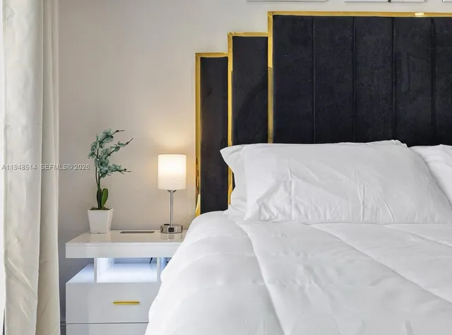 a bed sitting in a bedroom and wooden floor