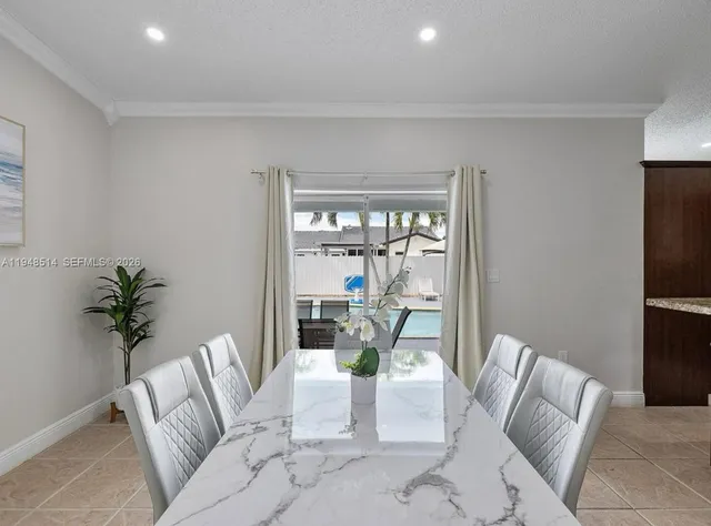 a living room with furniture floor to ceiling window and potted plant