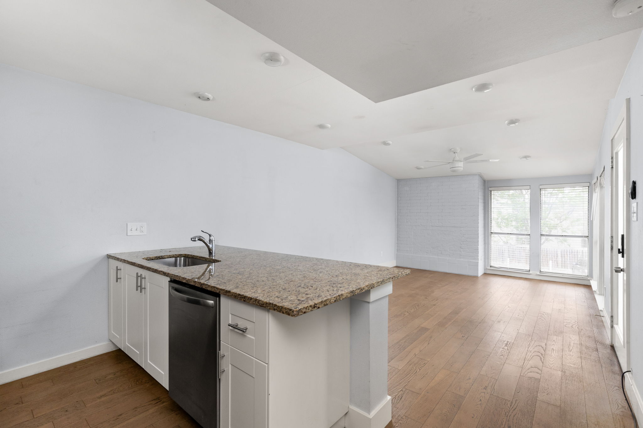 909 Reinli Street, Unit 232 Austin, TX 78751 - Photo 9 of 13 a kitchen with stainless steel appliances granite countertop a sink and wooden floor