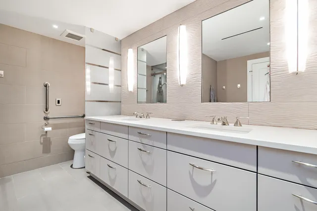 a bathroom with a toilet a sink a mirror and a shower