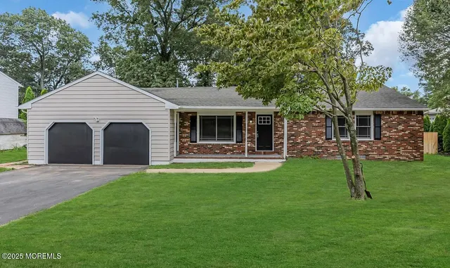 a front view of a house with a yard and trees