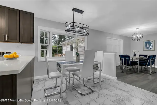 a view of dining room and livingroom with furniture wooden floor a chandelier
