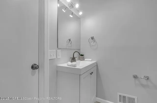a bathroom with a sink a light fixture and a vanity