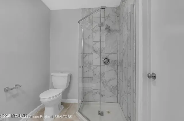 a bathroom with a toilet and a shower