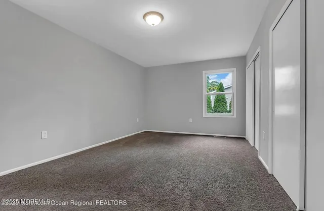 an empty room with windows and closet