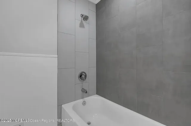 a bathroom with a white bath tub and a shower