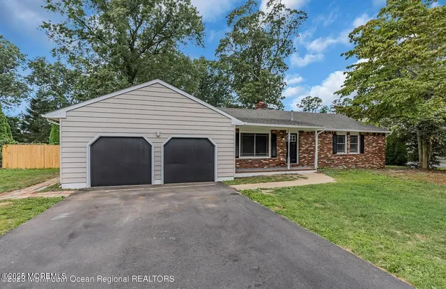 a front view of a house with yard and green space