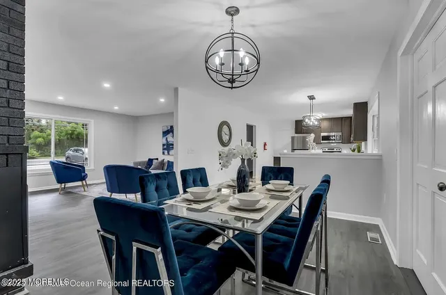 a view of a dining room with furniture a rug and wooden floor
