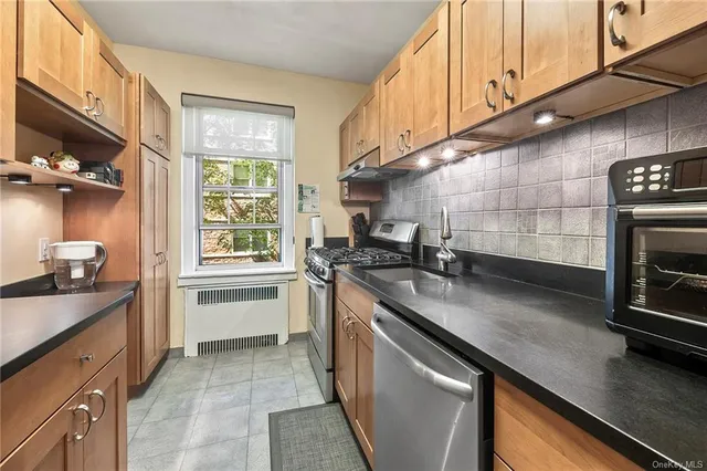 a kitchen with stainless steel appliances a sink stove and cabinets