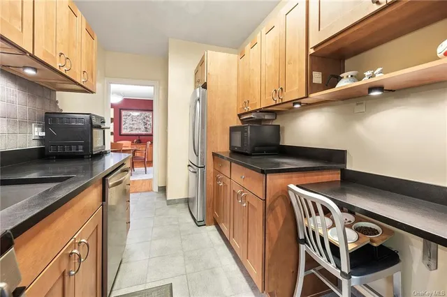 a kitchen with stainless steel appliances granite countertop a sink a stove and a refrigerator