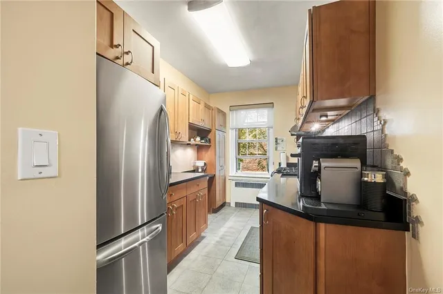 a kitchen with stainless steel appliances granite countertop a refrigerator a oven and a sink with wooden floor