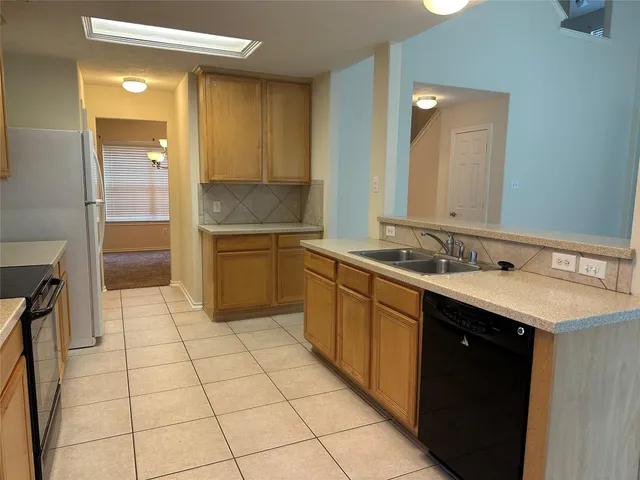 a large kitchen with a sink and cabinets