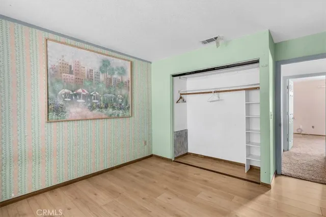 an empty room with wooden floor and a hallway