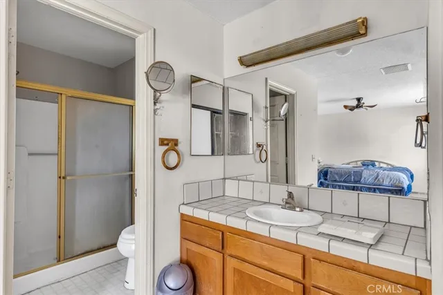 a bathroom with a granite countertop sink a toilet and a mirror