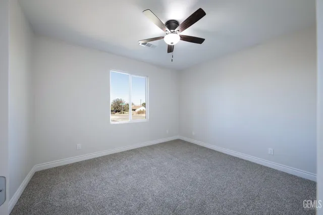 an empty room with a window and a ceiling fan