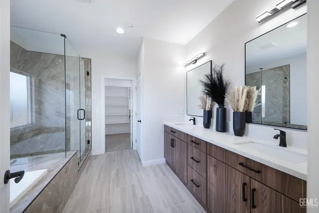 a bathroom with a double vanity sink mirror and shower
