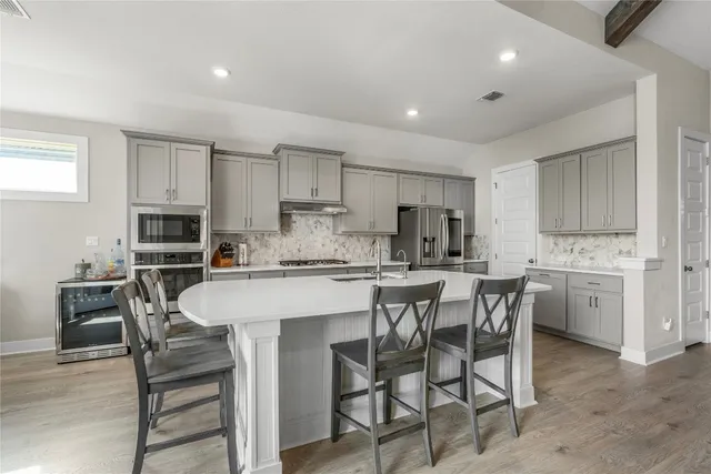 a kitchen with a table chairs microwave and cabinets