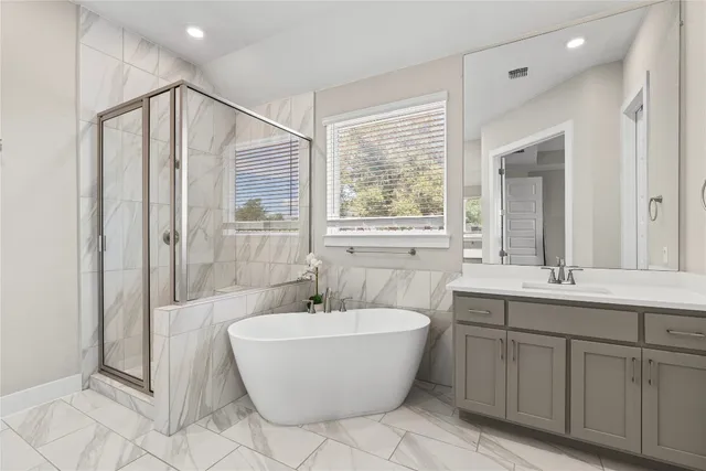 a bathroom with a white tub a vanity and a shower
