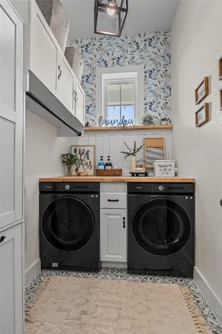 a utility room with sink washing machine and a rug