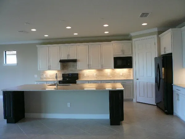 a kitchen with stainless steel appliances kitchen island granite countertop a stove a refrigerator and a microwave