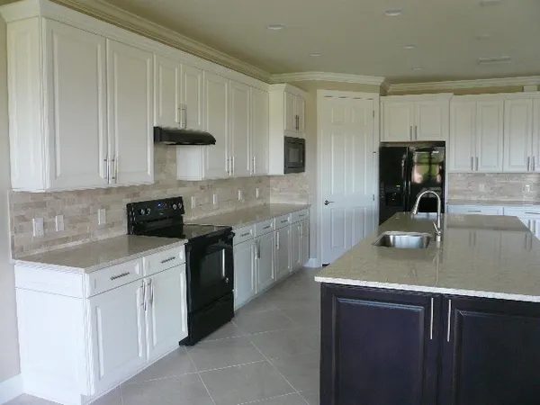 a kitchen with cabinets appliances a sink and a counter top space