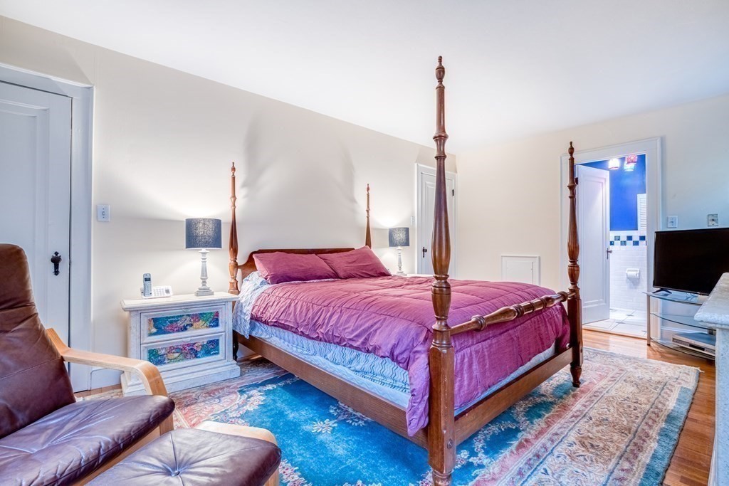 222 Bonad Road Brookline, MA 02467 - Photo 15 of 30 a spacious bedroom with a bed a couch and a flat screen tv