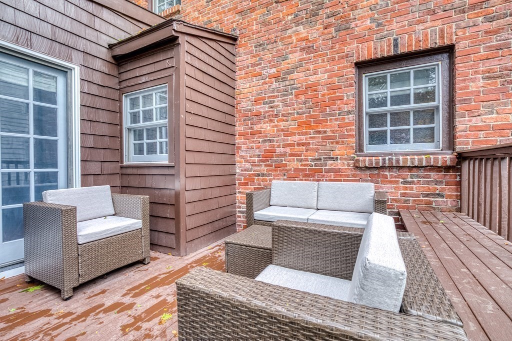 222 Bonad Road Brookline, MA 02467 - Photo 27 of 30 a view of a patio with couches and a dining table and chairs with wooden floor