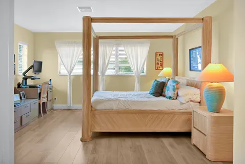 a bedroom with a bed and wooden floor