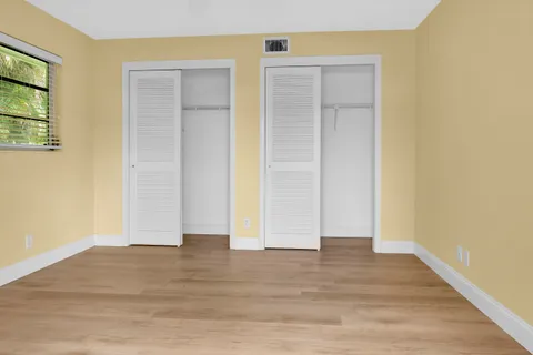 a view of empty room with wooden floor and entryway