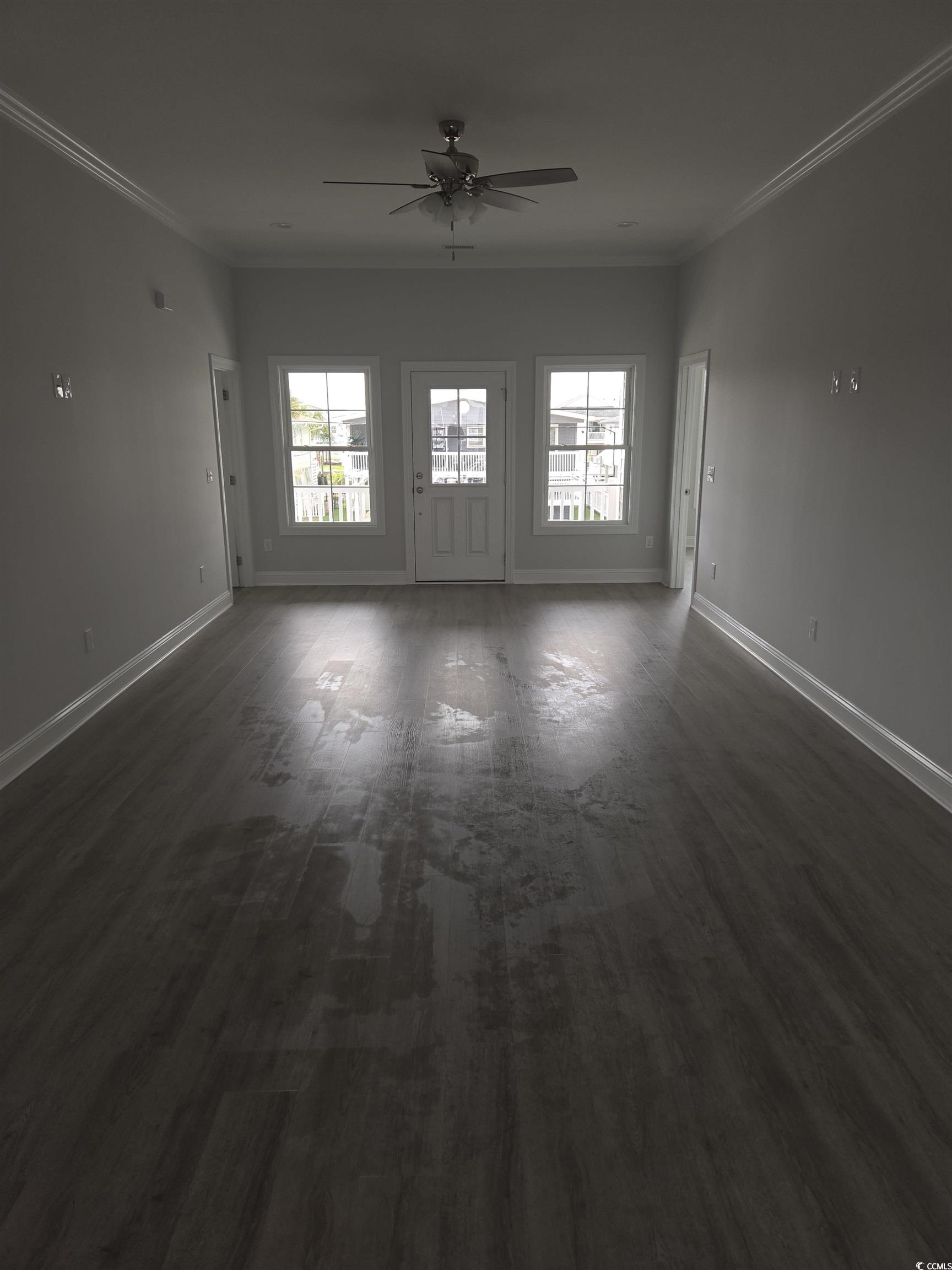 Empty room featuring ceiling fan, crown molding, a