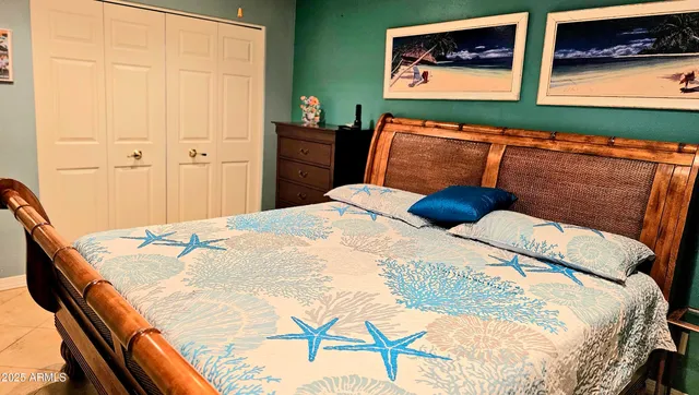 a bedroom with a bed and painting on the wall